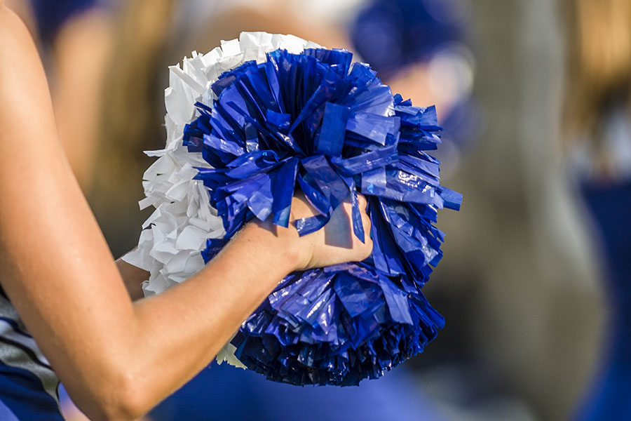 Cheer Gym Insurance - Woman Holding Blue and White Pom Poms at the Cheer Gym
